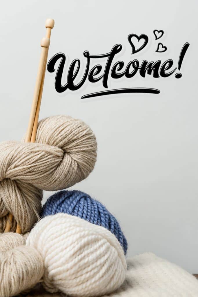 Skeins of yarn and knitting needles with welcome